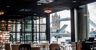Elegant restaurant interior with a view of Tower Bridge in London.