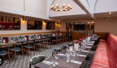 Elegant restaurant interior with long tables set for dining.