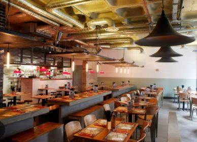 Cozy modern restaurant interior with warm lighting and wooden furniture.