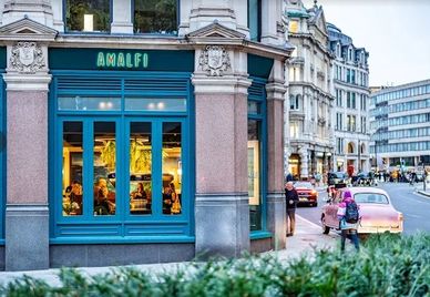 Street view of Amalfi restaurant with classic architecture and vintage car.