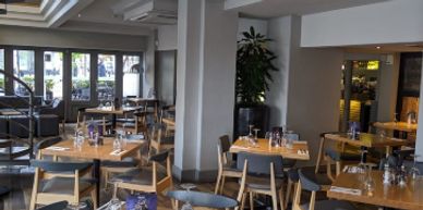 Empty modern restaurant interior with wooden tables and chairs.