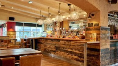 Cozy bar interior with rustic wood and warm lighting.