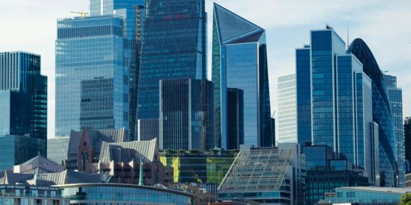 Modern skyscrapers dominate a clear city skyline under a blue sky.