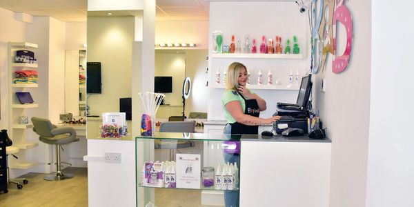 Long shot of Bertie and Belle's children's hair salon with a hair stylist answering phone