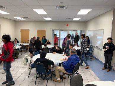 People socializing and eating in a community room.