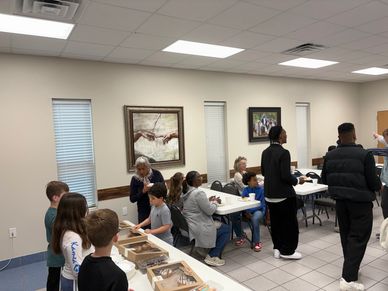 Children and adults gathered in a community room for an activity or event.