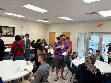 People enjoying food and socializing in a community gathering room.