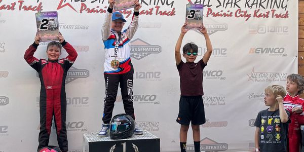 Young karting champions hold their awards on the podium at All Star Karting Prairie City Kart Track.