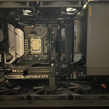 Open PC case showing motherboard, GPU, and cooling fans.