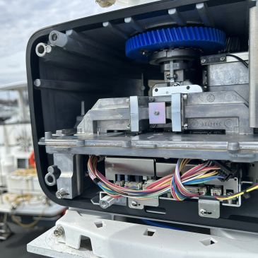 Inside view of a mechanical device with gears and wires.