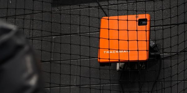 TrackMan radar system is capturing real-time pitch data as a ball leaves the pitcher’s hand.
