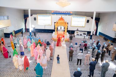 People gathered in a Sikh temple for a religious ceremony.