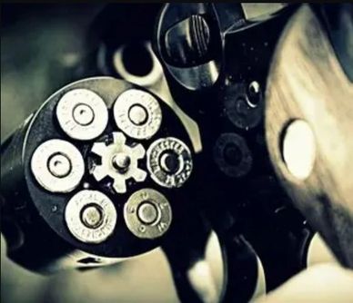 Close-up of a revolver cylinder loaded with six bullets.