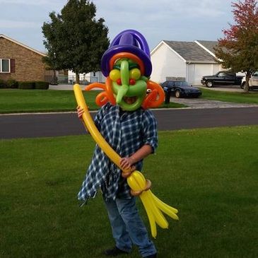 Entertainer dressed in a witch Halloween costume made of balloons.