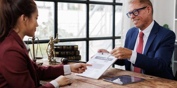 Two professionals discussing and signing a contract in an office.