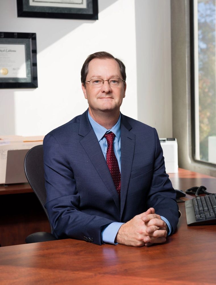 Professional man in a suit sitting confidently at his office desk.