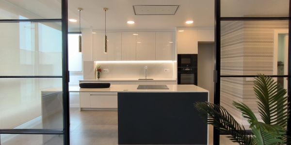 Cocina moderna y minimalista con isla y detalles en negro y blanco.