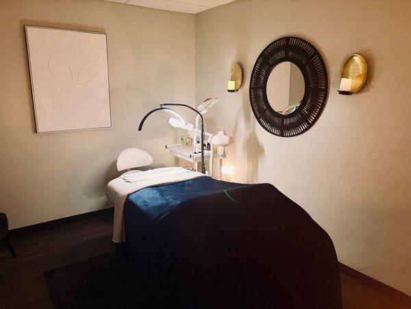 Cozy spa treatment room with a massage table and soft lighting.