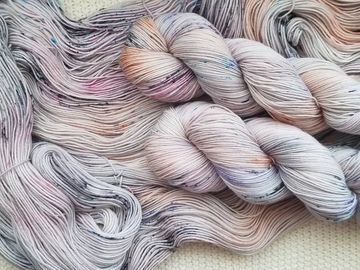 Grey, pink and orange yarn on a cream background