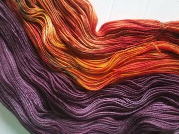 Orange and purple skeins on a white background.