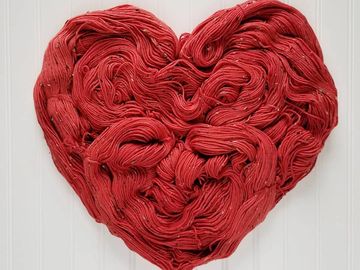 A red heart shaped out of dk donegal yarn