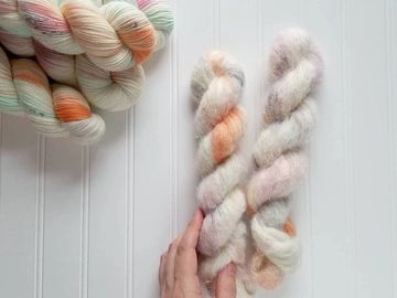 Multiple skeins of Euphoria on multiple bases, with the focus placed on two Arabesque suri/silk bases.