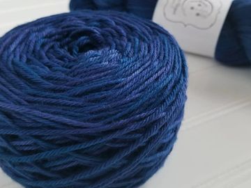A blue skein of Cetus caked up, with a skeined Cetus in the bacground