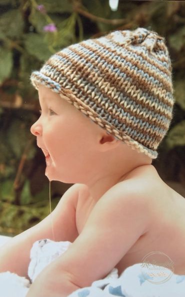A baby wearing a striped knitted hat with drool on the chin.