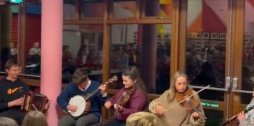 Group of people playing folk instruments indoors.