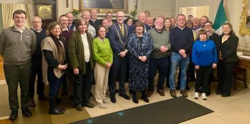 Group photo of adults in a formal room.