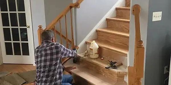 Homem consertando escada de madeira.