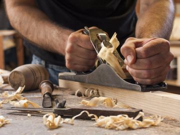 Carpenter sanding piece of wood