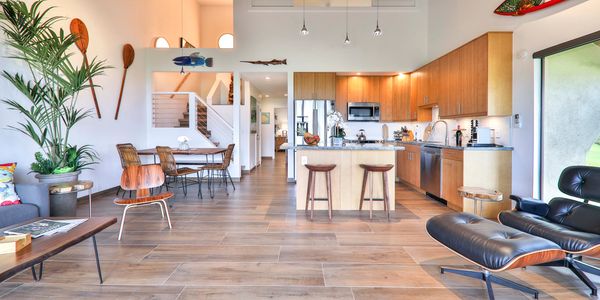 Wide angle view of Maui Dream Place condo. Eames Lounge Chair is displayed. Kitchen view is visible.