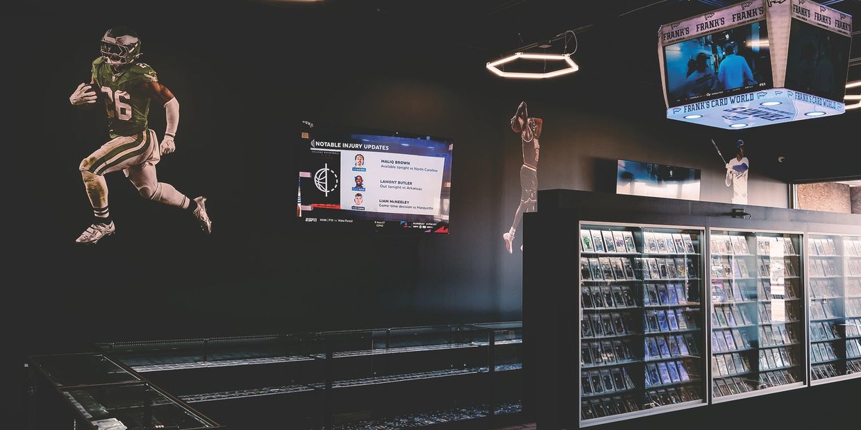 Sports-themed room with memorabilia and TVs.