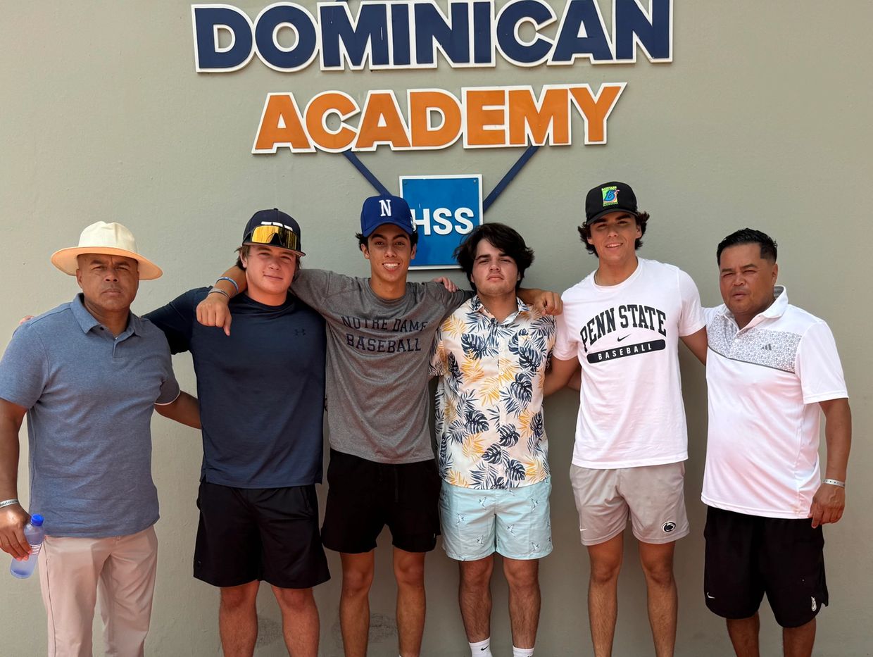 Group photo of six men standing under a Dominican Academy sign.