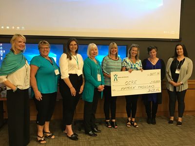 Belles with Balls NL committee members present a cheque to researchers at Memorial University. 