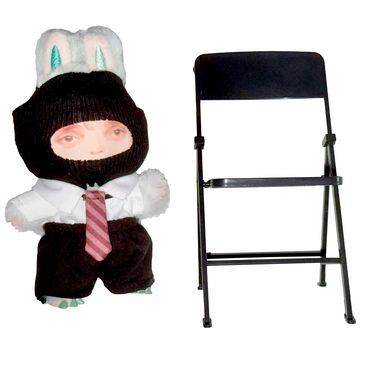 Stuffed bunny dressed in formal clothes next to a black folding chair.