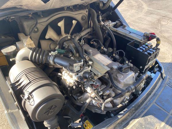 Car engine with cooling fan and air filter.