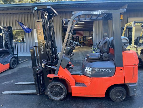 Orange Toyota forklift parked outdoors.