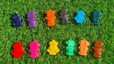 Colorful robot toys arranged on grass.