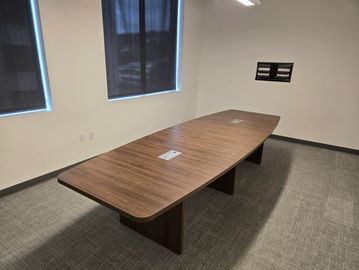 Modern walnut 12 foot boat shaped conference table in professional office setting