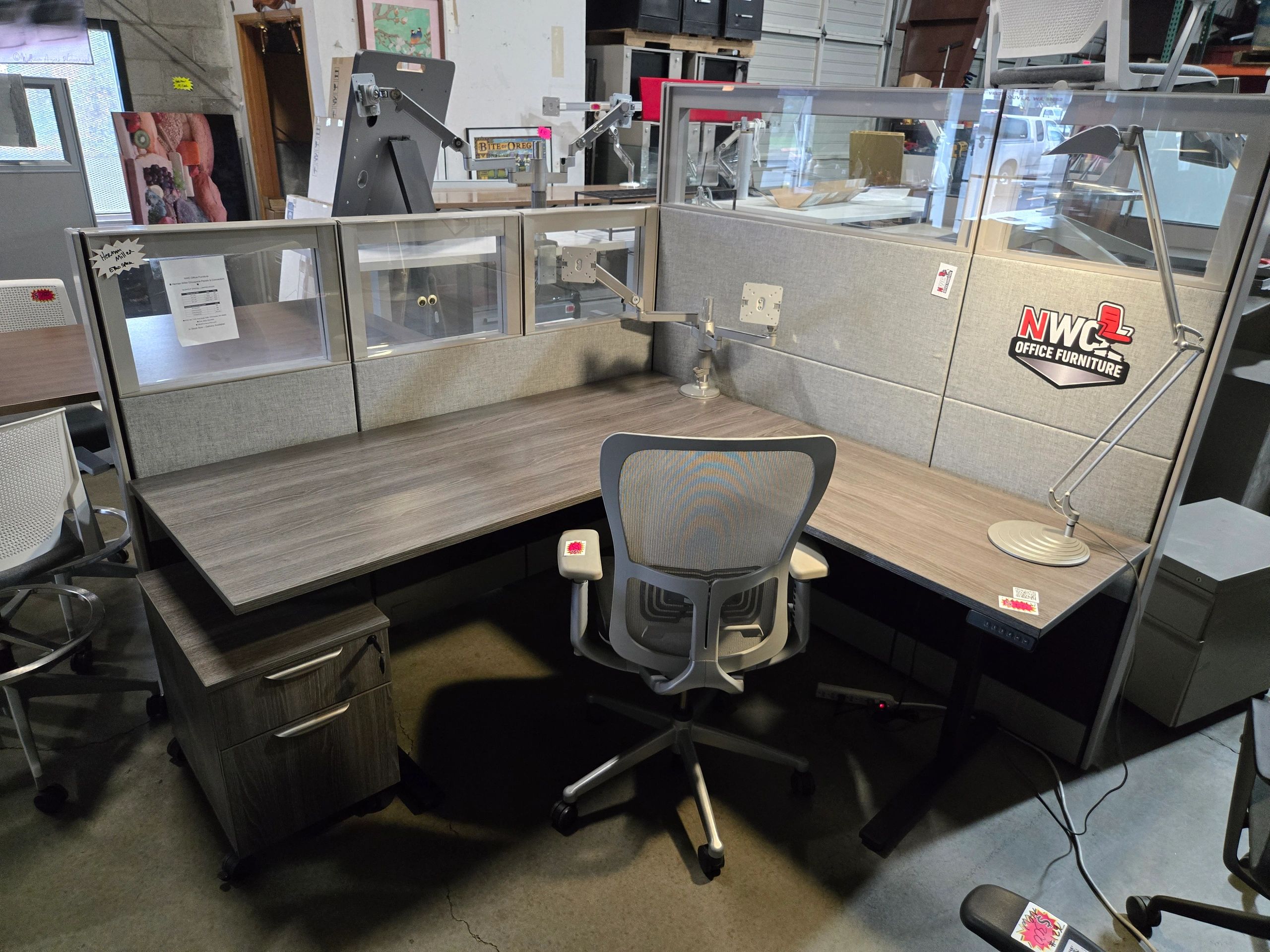 6x6 Herman Miller L-shaped sit-to-stand cubicle with NWC logo printed on the fabric 