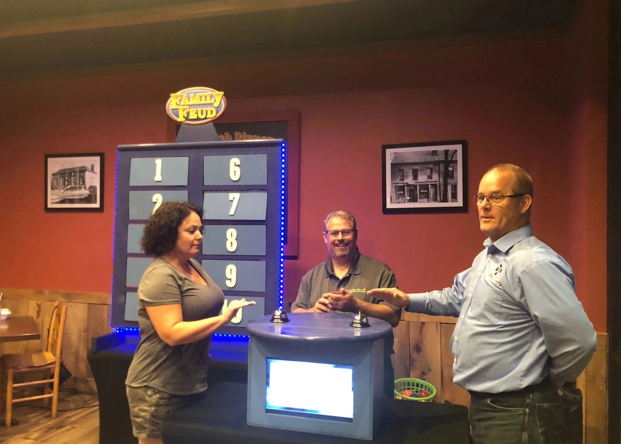 Guests gathered around an illuminated interactive game-show station during a live entertainment event.