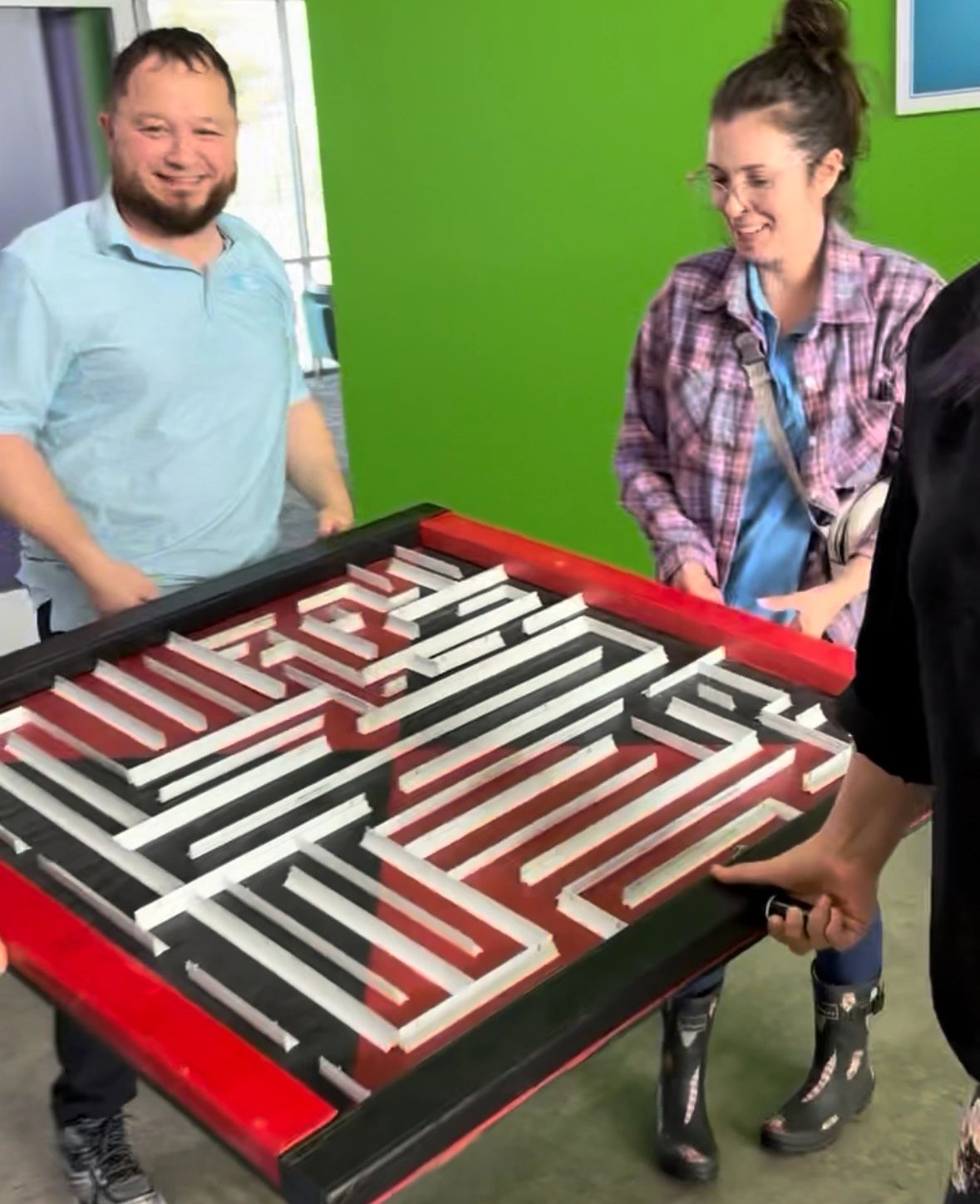 Two event guests working together to complete a tabletop maze game.