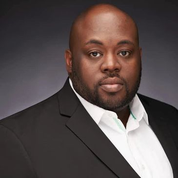 Professional portrait of a man in a black suit and white shirt.