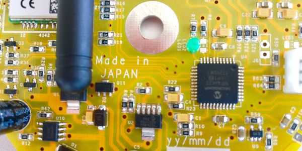 Close-up of a yellow circuit board labeled 'Made in Japan' with various electronic components.