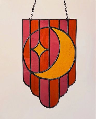 Yellow moon and star with alternating background of orange and purple stripes.