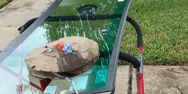 A glass table with a round cardboard piece and various small items on it.