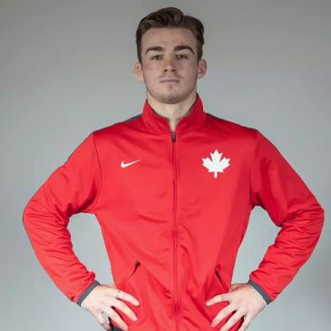 Man in a red jacket with a maple leaf emblem.