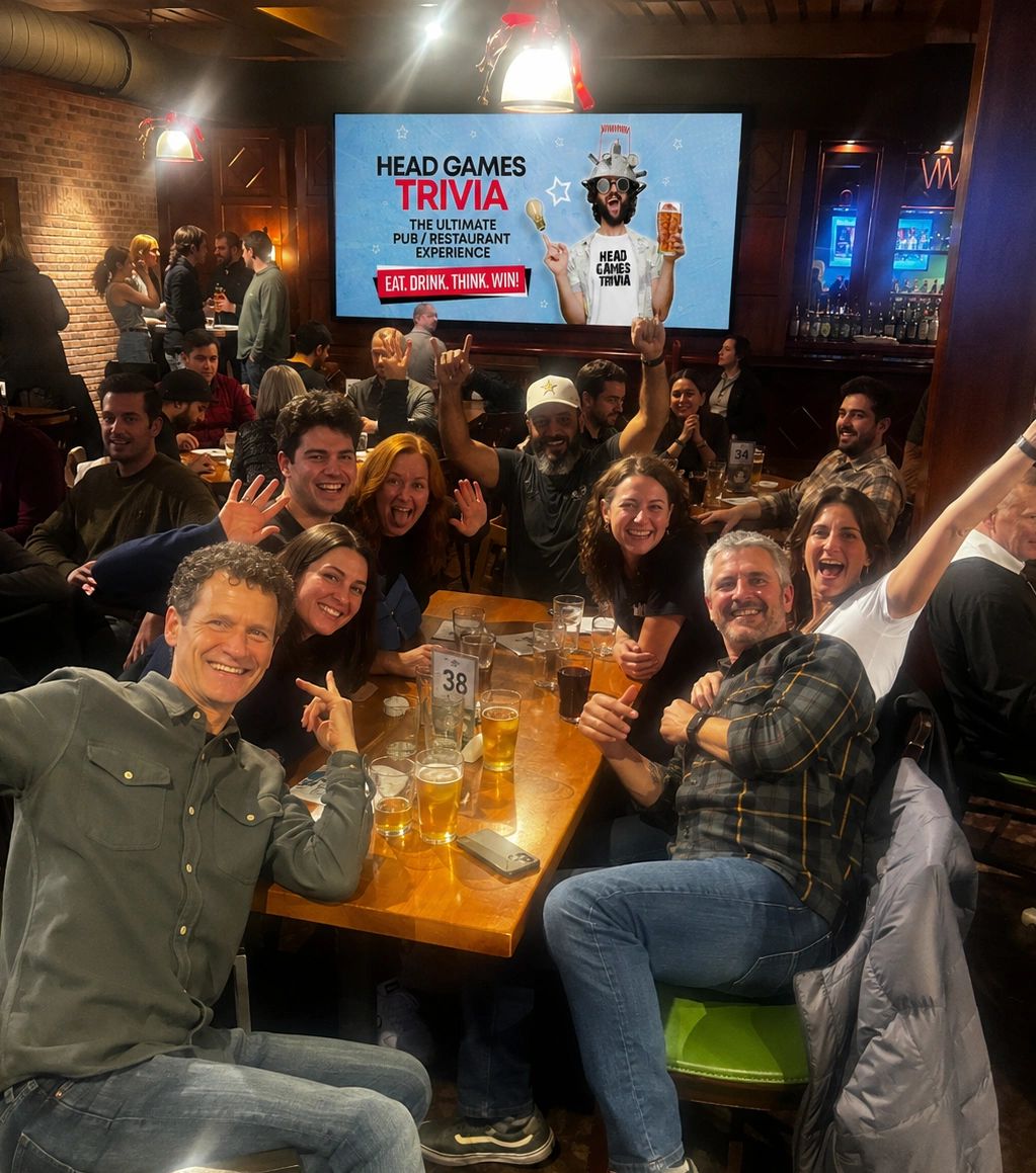 Group of friends enjoying a lively pub trivia night with drinks and smiles.